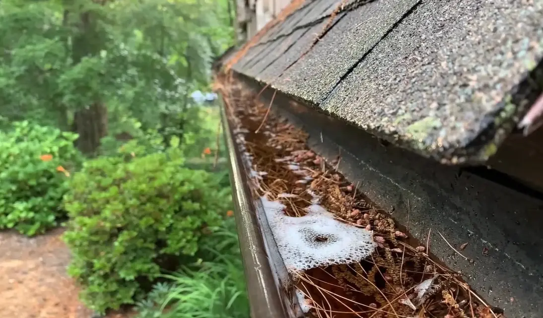 Clogged gutter overflowing with rainwater during a storm in Richmond, VA