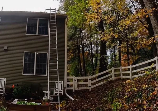 Ladder setup for clearing a downspout connected to underground drainage in Richmond, VA